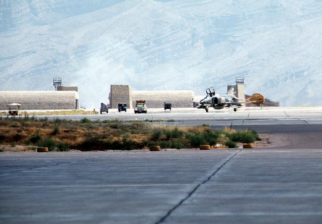 Left front view of an F-4 Phantom II aircraft, with its drag chute deployed, landing at Shiraz Air Base during exercise Cento. (August 1, 1977)
