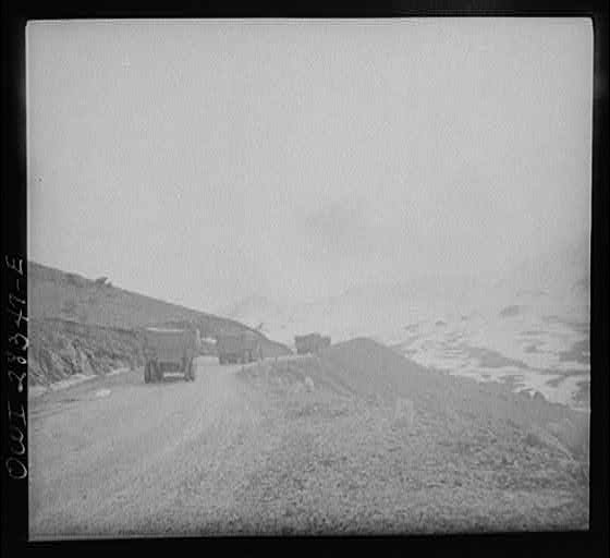 Somewhere in the Persian corridor. A United States Army truck convoy carrying supplies for Russia climbing a mountain road.