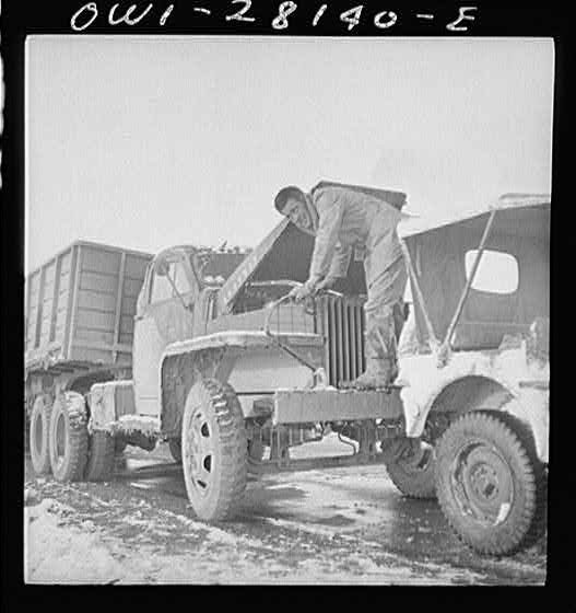 A truck driver checking the oil. He is with a United States Army truck convoy carrying supplies for the aid of Russia. Somewhere in the Persian corridor.