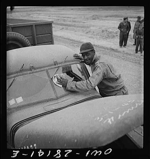 Somewhere on the Persian corridor with a United States Army truck convoy carrying supplies for the aid of Russia. The driver cleaning the desert dust off his windshield.