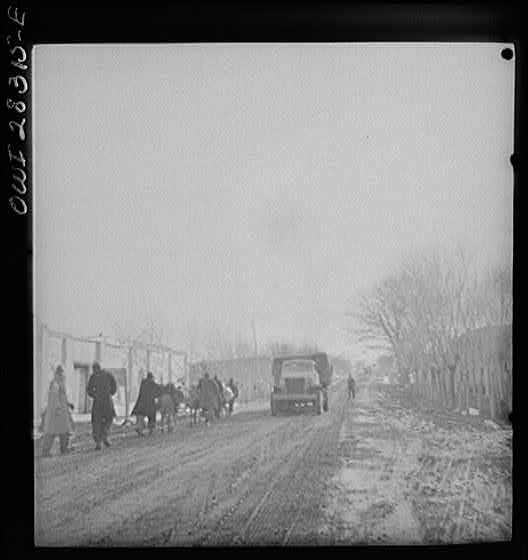 Somewhere in the Persian corridor. A United States Army truck convoy carrying supplies for the aid of Russia. The convoy passing through a Persian village.