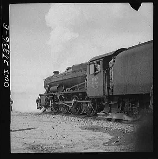 An American locomotive with an American soldier crew hauling freight to Russia somewhere in Iran.