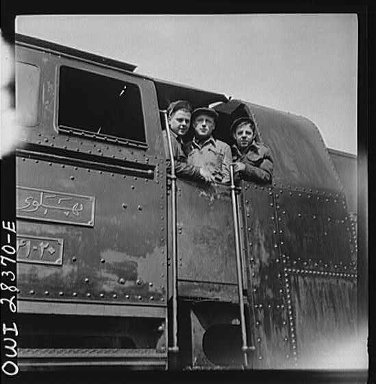 American, Russian and English engineers in the cab of an engine. Each of them has done his part in hurrying supplies enroute to Russia along a railroad in Iran.