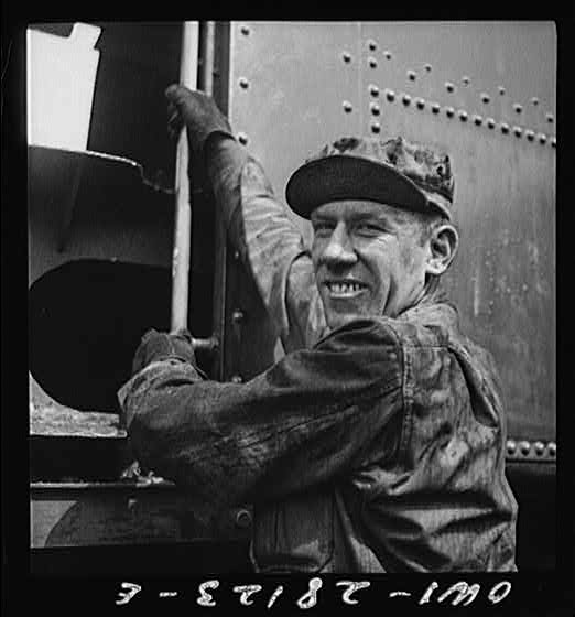 An American soldier engineer climbing into the cab of his train. An engineer in private life, he is happy at the chance to push supplies in the aid to Russia drive. Somewhere in Iran.
