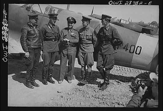 Somewhere in Iran. Major General Lewis Brererton in the center, the Commander of the United States Army force in the Middle East, with a group of Russian officers standing before an American warplane delivered to the Russians. A United States warplane is being tested in the background and bears the red star insignia of Russia, which is made by filling in the white star of the United States with red paint
