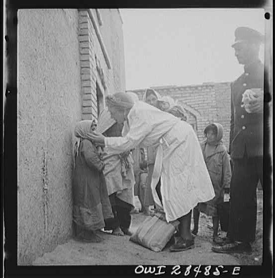Teheran, Iran. Mrs. Louis Dreyfus, wife of the United States Minister to Iran, distributing food and medical supplies in the poorer section of the city.