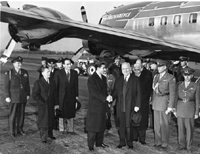 Photograph of President Truman and the Shah of Iran shaking hands at Washington National Airport upon the Shah's arrival in the United States, with the President's airplane, 