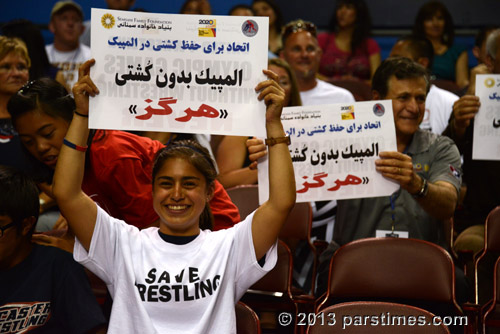 An Iranian-American girl holding a sign 'Olympics without wrestling: Never' - LA Sports Arena (May 19, 2013) - by QH