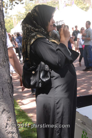 Conservative Muslim-American woman wearing dark all-black hijab in hot weather