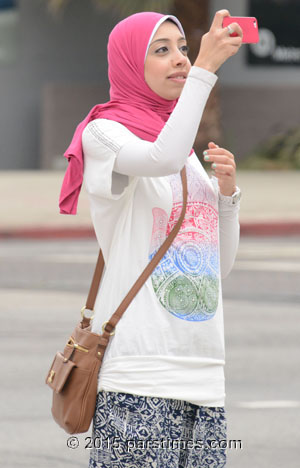 A young muslim woman looking cool wearing a pink scarf
