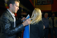 Actor Ryan Dillon signing the movie poster for a fan - By QH